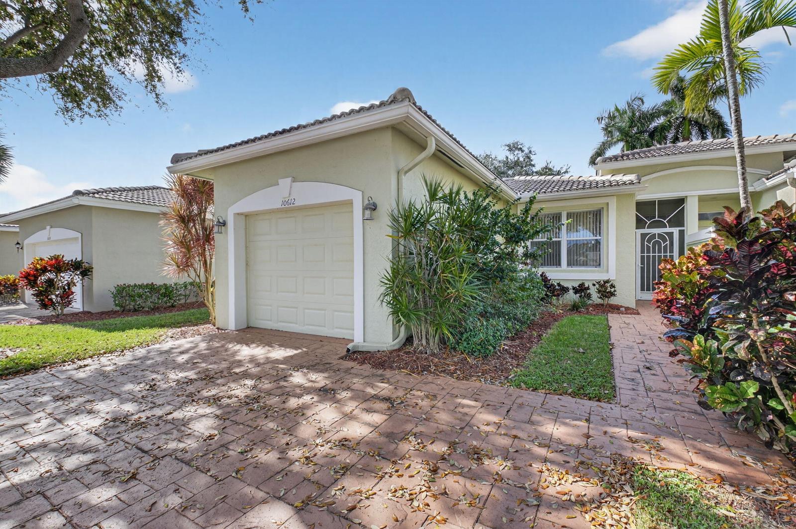 A single-story house with a light green exterior, a one-car garage, and a paved driveway — 10612 Royal Caribbean Circle, Boynton Beach FL 33437, BOYNTON BEACH, FL