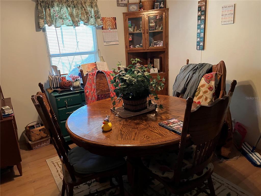 A dining room features a round wooden table, four chairs, and a corner hutch — 12501 SW HIGHWAY 200, DUNNELLON, FL