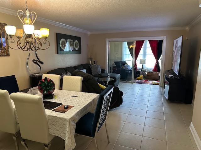 A dining area with a chandelier opens into a living room with tile flooring — 7600 NW 5th Place # 106, Margate FL 33063, MARGATE, FL