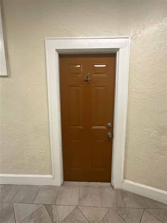 A brown door marked with the number four is set in a white frame — 2608 CENTRAL AVENUE UNIT 4, ST PETERSBURG, FL
