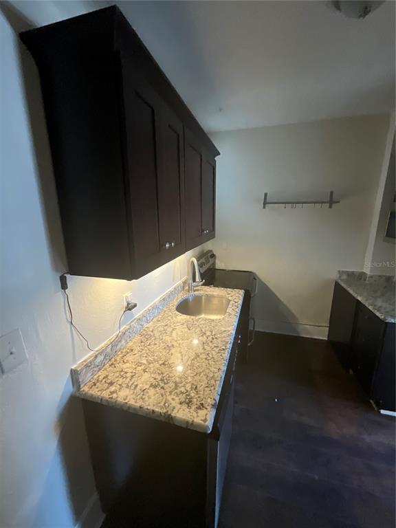 A kitchen features dark cabinets, a granite countertop, a stainless steel sink, and under-cabinet lighting — 2608 CENTRAL AVENUE UNIT 4, ST PETERSBURG, FL