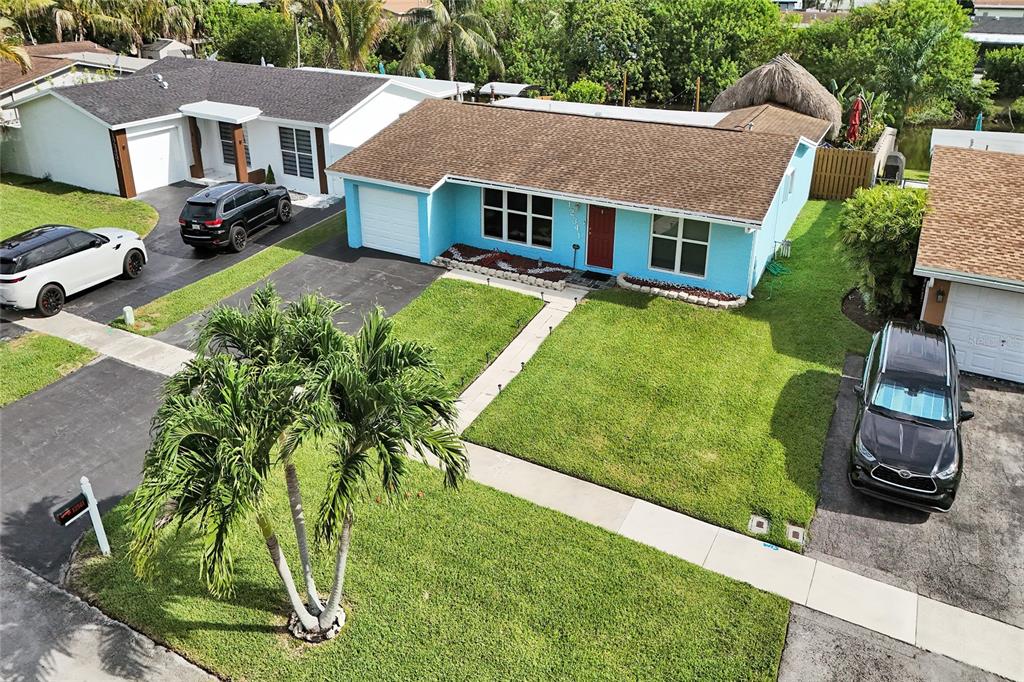 An aerial view shows a light blue house with a brown roof and a palm tree — 12341 NW 29TH MANOR, SUNRISE, FL