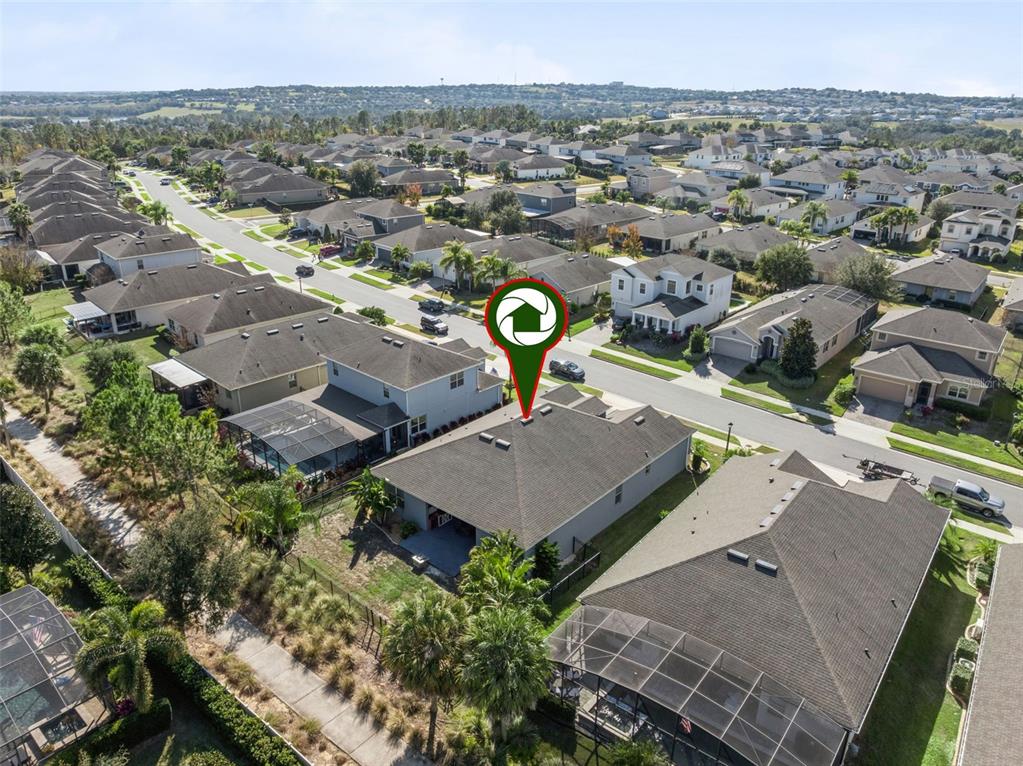 An aerial view shows a house with a backyard pool, spa, and fire pit area — 1025 SADIE RIDGE ROAD, CLERMONT, FL