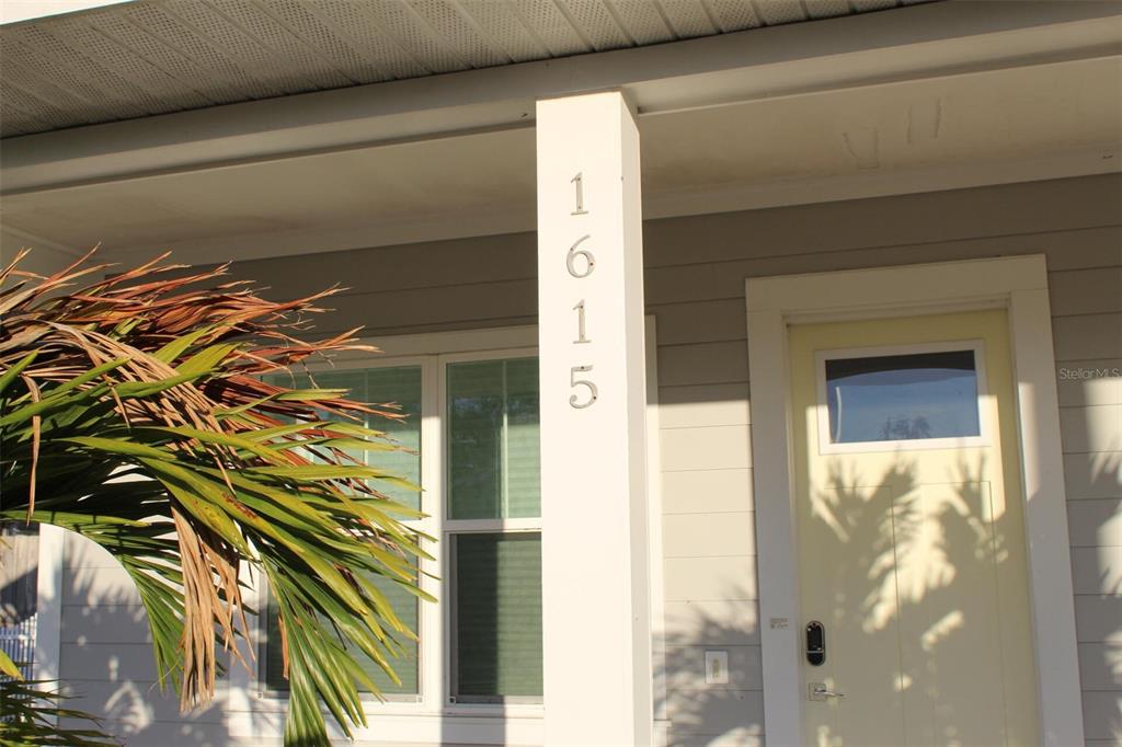 The exterior of a house features a white porch column displaying the house number 1615 — 1615 17TH STREET W, BRADENTON, FL