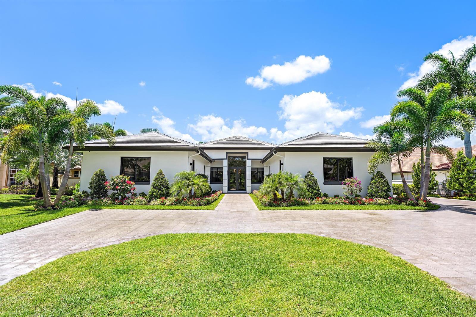 A white single-story house with a tiled roof, palm trees, and a paved driveway — 6087 Wildcat Run, West Palm Beach FL 33412, WEST PALM BEACH, FL