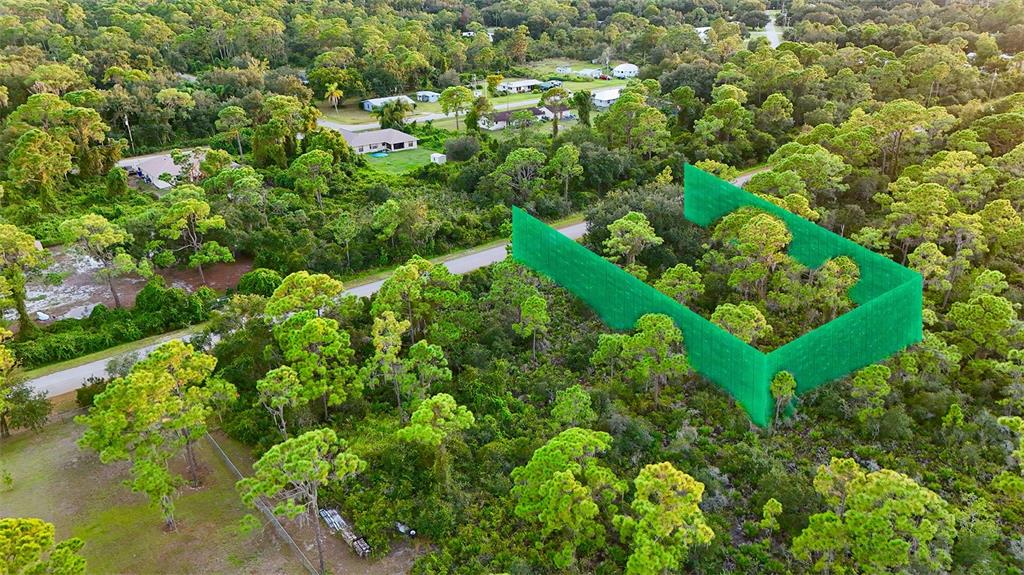 An aerial view shows a vacant, wooded lot with a green construction silt fence perimeter — 1510 ERROL STREET, LAKE PLACID, FL