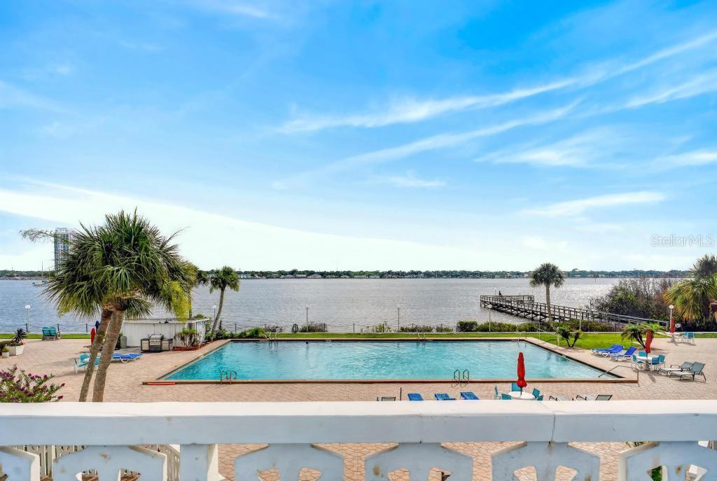 A swimming pool sits on a patio overlooking a large body of water — 925 N HALIFAX AVENUE UNIT 410, DAYTONA BEACH, FL