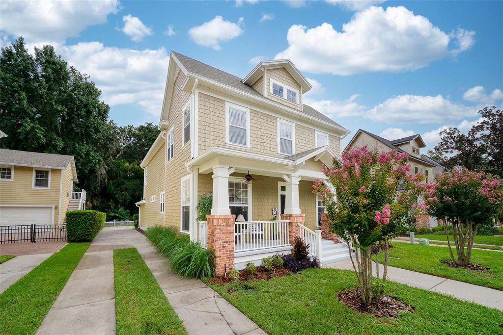 A two-story house with tan shingle siding, a front porch, and a concrete driveway — 1103 BANKS ROSE COURT, CELEBRATION, FL