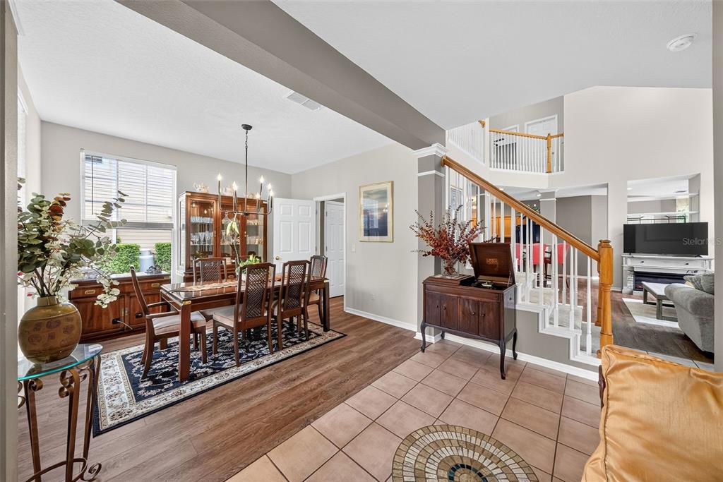 A dining area with wood flooring and a staircase leading to an upper level — 1103 BANKS ROSE COURT, CELEBRATION, FL