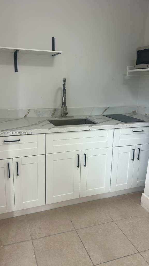A small kitchen features white shaker cabinets, a marble-look countertop, and a stainless steel sink — 2467 NW 103rd St # 2, Miami FL 33147, MIAMI, FL