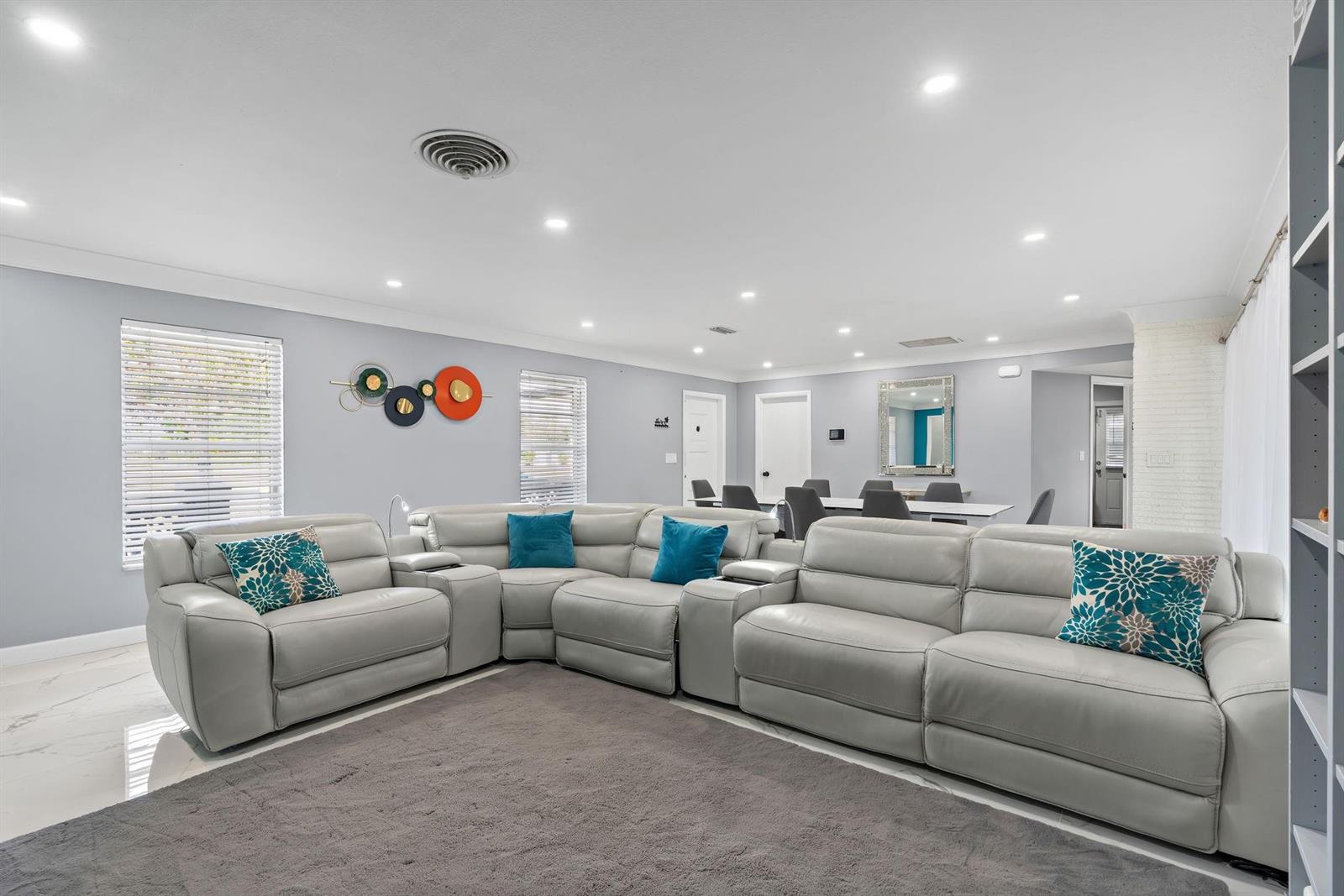 A spacious living room features light gray leather sectional seating on a dark area rug — 7328 Saint Andrews Road, Lake Worth FL 33467, LAKE WORTH, FL
