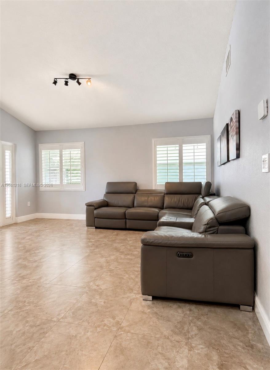 A living room features light gray walls, tile flooring, and a large brown sectional sofa — 12224 NW 30th Mnr, Sunrise FL 33323, SUNRISE, FL