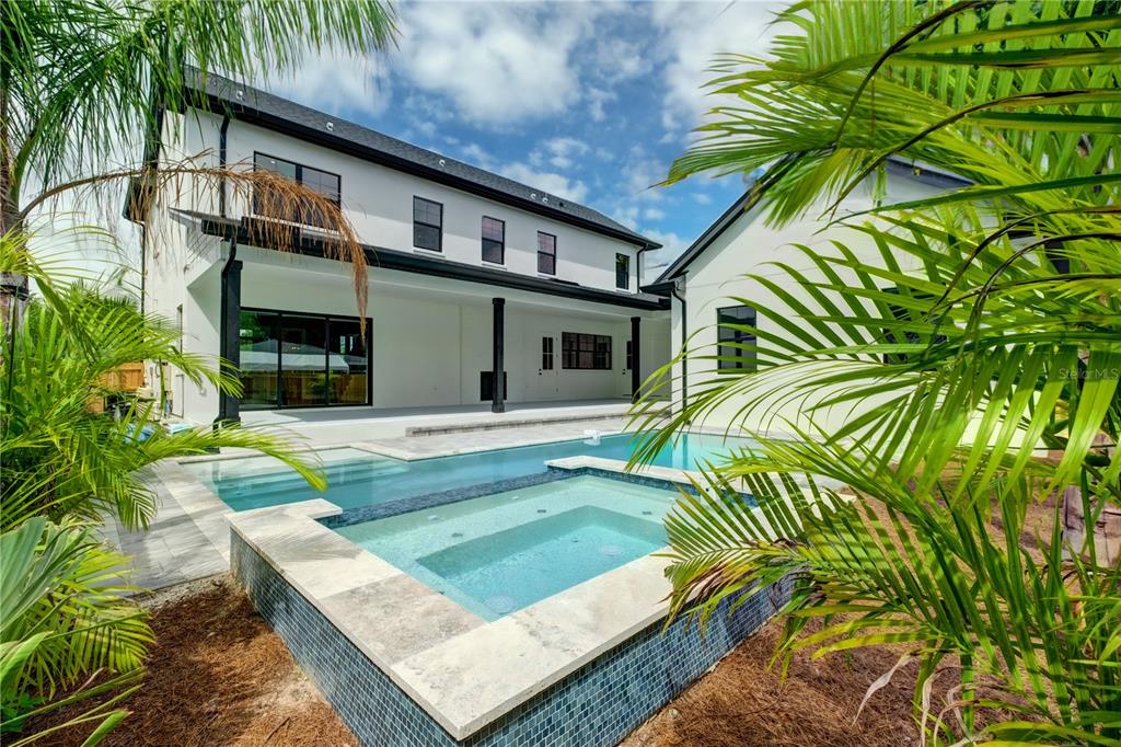 A modern two-story house features a backyard swimming pool and attached spa with tile accents — 805 W INDIANA AVENUE, TAMPA, FL