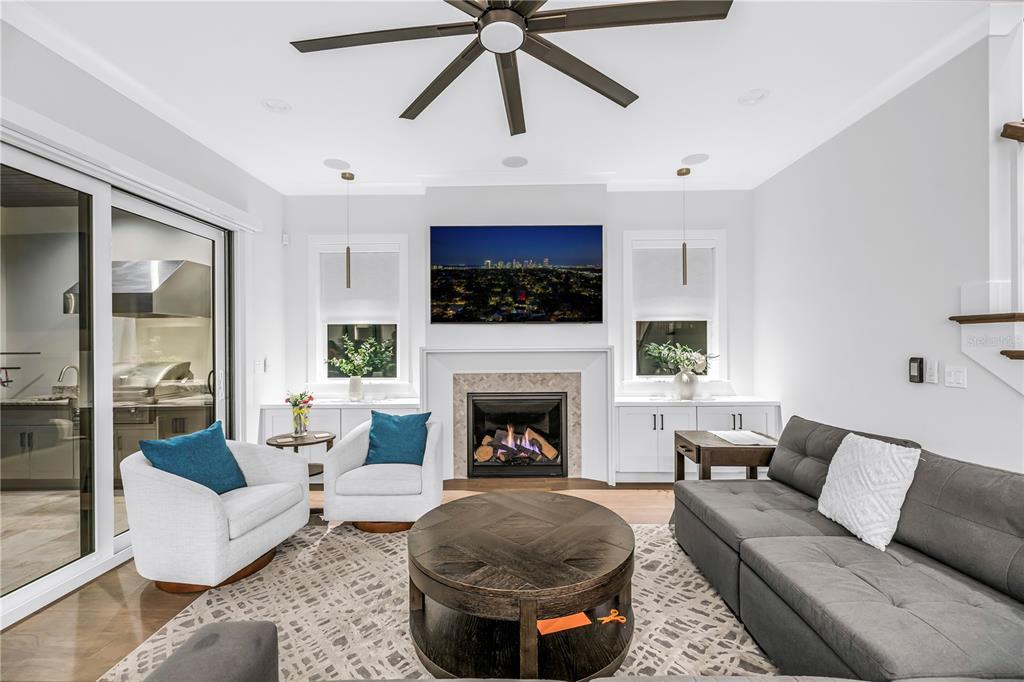 A living room with a grey sectional sofa and coffee table opens to a kitchen — 151 17TH AVENUE N, ST PETERSBURG, FL