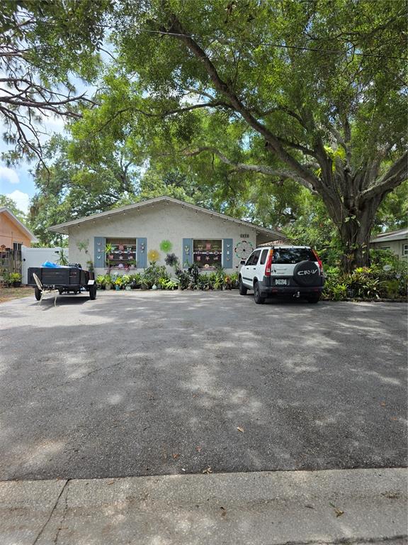 A single-story house with a large asphalt driveway, a parked SUV, and a utility trailer — 3074 PINE TREE AVENUE UNIT B, LARGO, FL