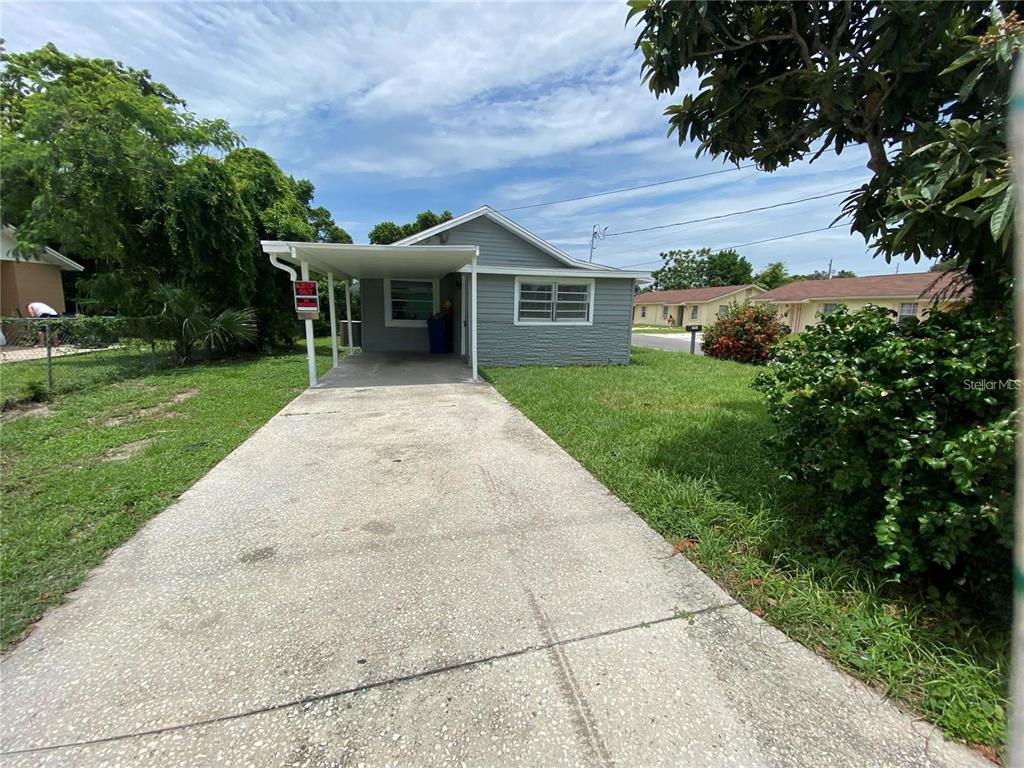A single-story gray house with a concrete driveway and an attached carport — 306 PALMETTO AVENUE NW, WINTER HAVEN, FL