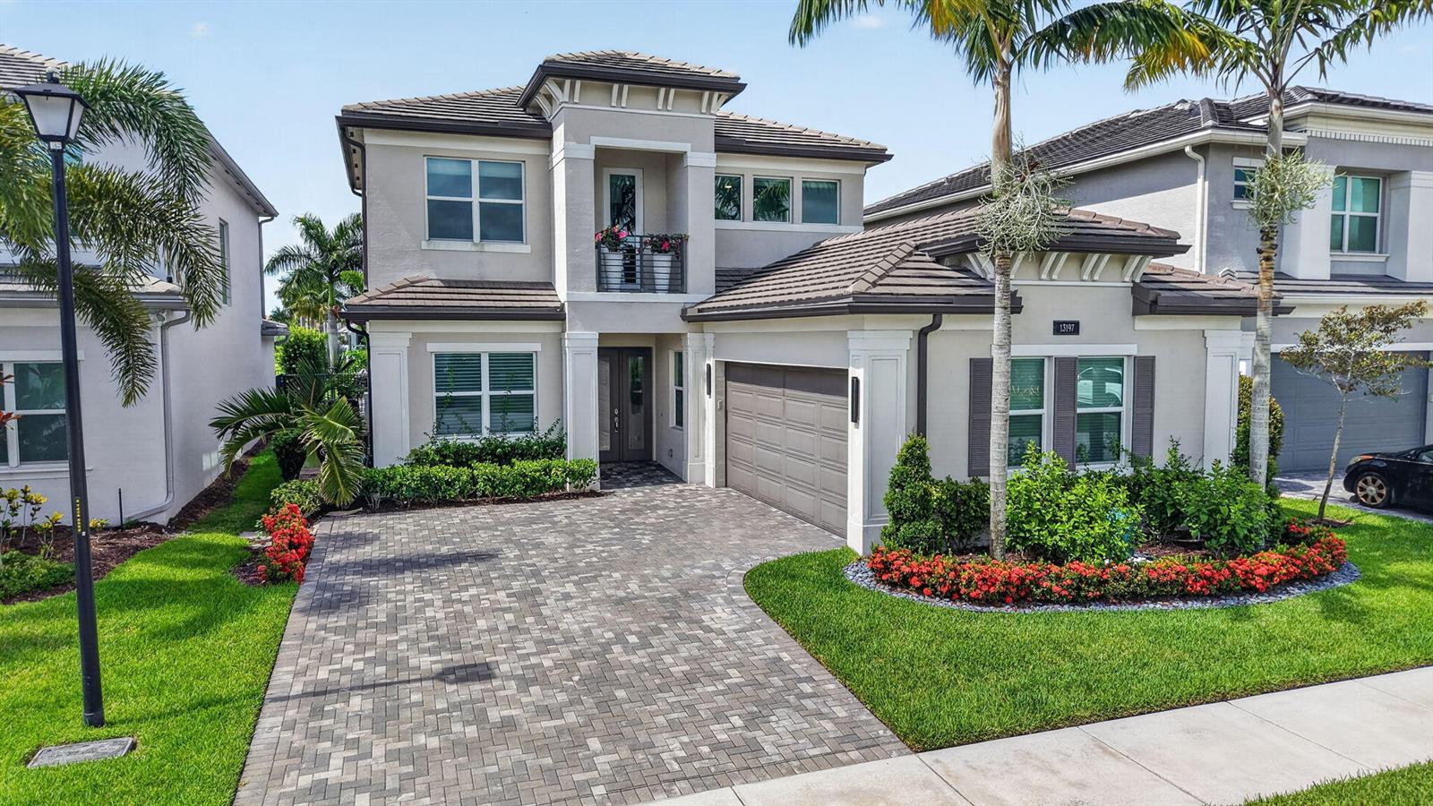 A two-story suburban house features a paved driveway, a garage, and a small balcony — 13197 Whistler Mountain Road, Delray Beach FL 33446, DELRAY BEACH, FL