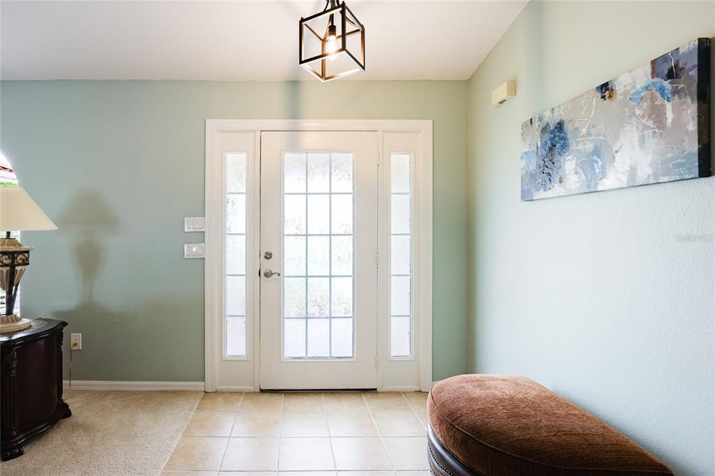 A foyer features a white front door with sidelights, tile flooring, and a light fixture — 24102 SANTA INEZ ROAD, PUNTA GORDA, FL