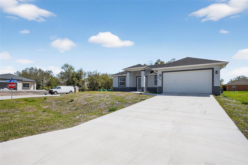 A single-story house with a concrete driveway, two-car garage, and a grassy front yard — 4630 GENE AVENUE N, LEHIGH ACRES, FL