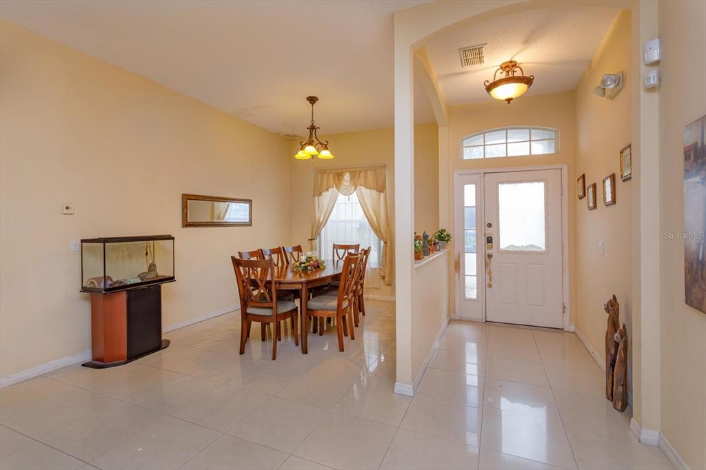 A dining area with a table and chairs sits adjacent to a tiled entryway — 244 BALLYSHANNON DRIVE, DAVENPORT, FL