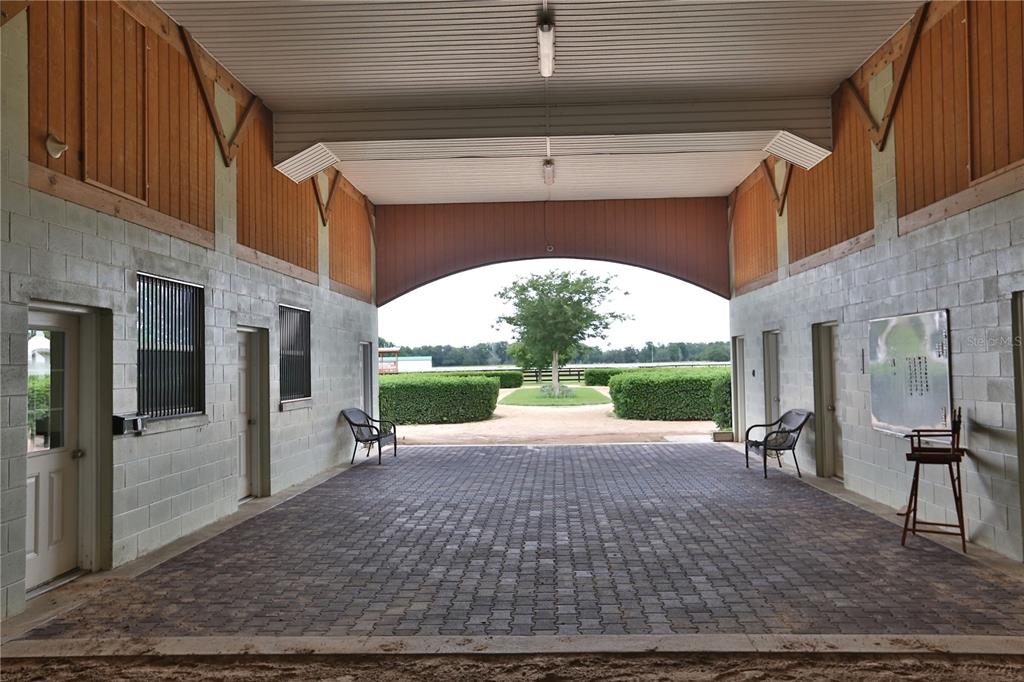 A covered breezeway with brick pavers leads to an outdoor view of a landscaped yard — 19431 NE 17TH PLACE, WILLISTON, FL