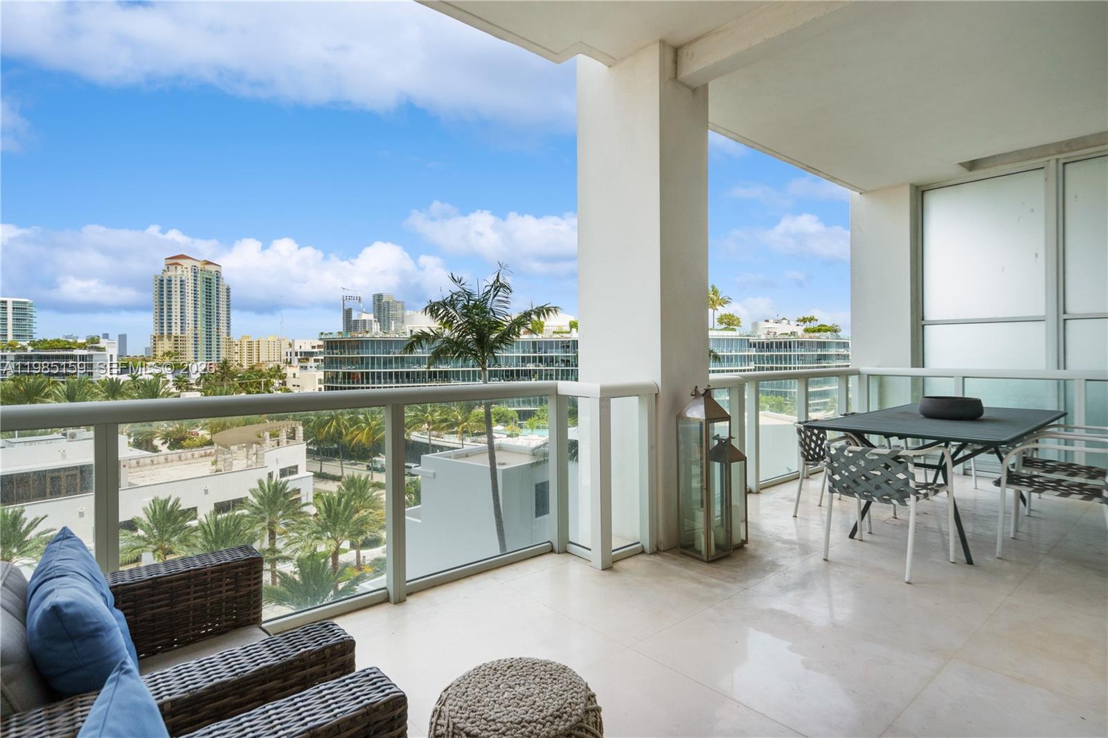 A spacious balcony features tile flooring, outdoor furniture, and a view of city buildings — 50 S Pointe Dr # 805, Miami Beach FL 33139, MIAMI BEACH, FL