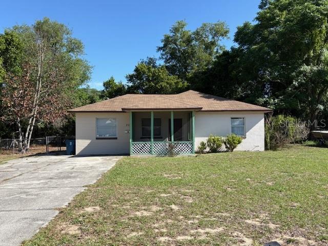 A single-story house with a brown roof, light-colored siding, and a front porch — 713 EUCLID AVENUE, LAKE WALES, FL