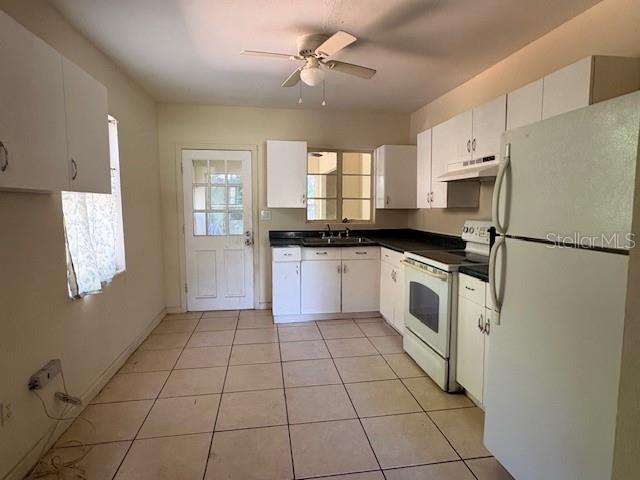 A kitchen with white cabinets, tile flooring, a ceiling fan, and a white refrigerator — 713 EUCLID AVENUE, LAKE WALES, FL