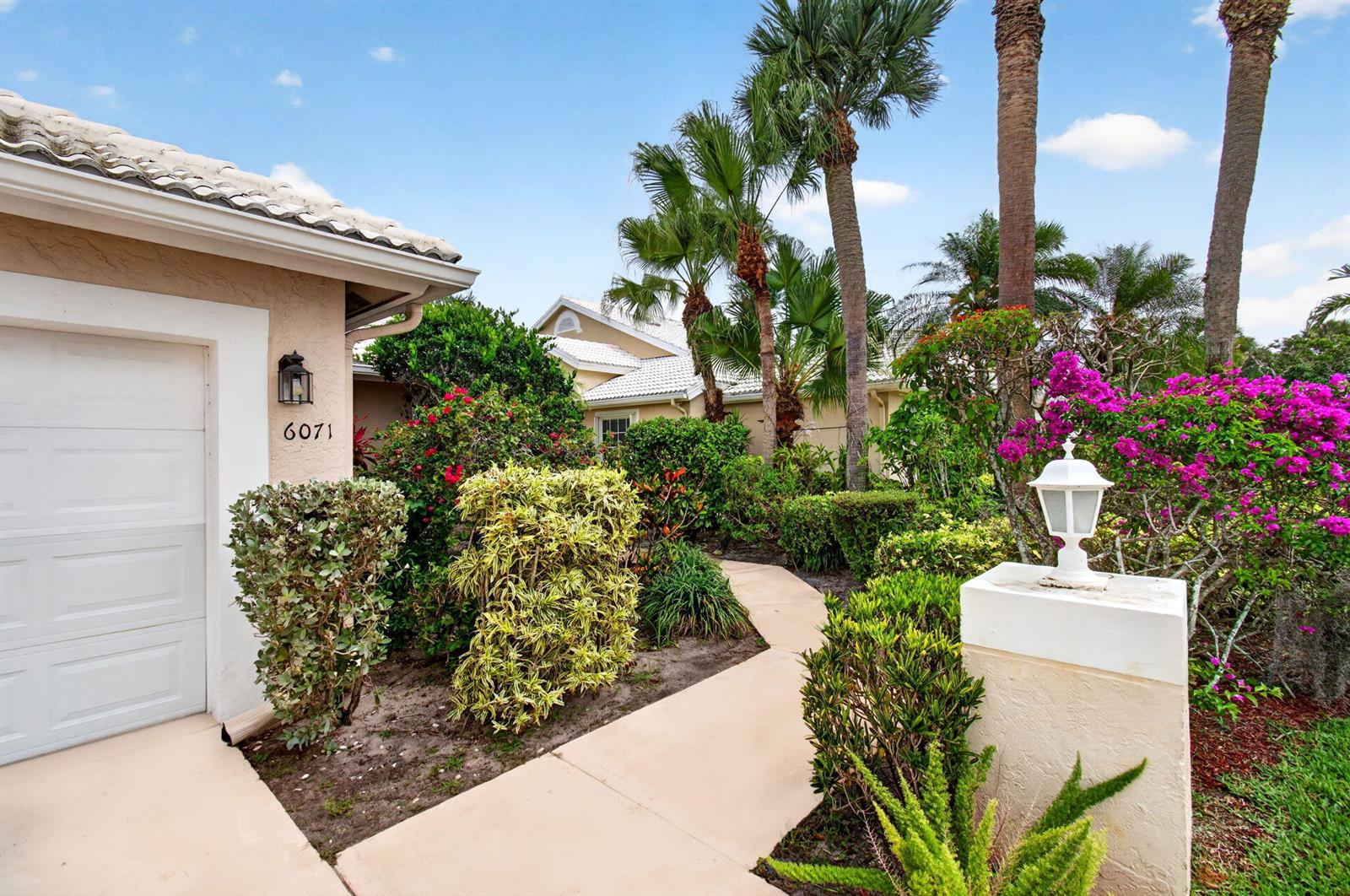 A concrete walkway leads to the entrance of a house with a garage and landscaping — 6071 Greenspointe Drive, Boynton Beach FL 33437, BOYNTON BEACH, FL