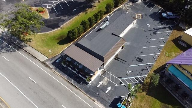 An aerial view shows a commercial building with a parking lot and adjacent road — 1518 S DIXIE FREEWAY, NEW SMYRNA BEACH, FL
