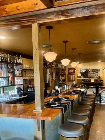 A wooden bar counter with stools and pendant lighting in a restaurant interior — 1518 S DIXIE FREEWAY, NEW SMYRNA BEACH, FL