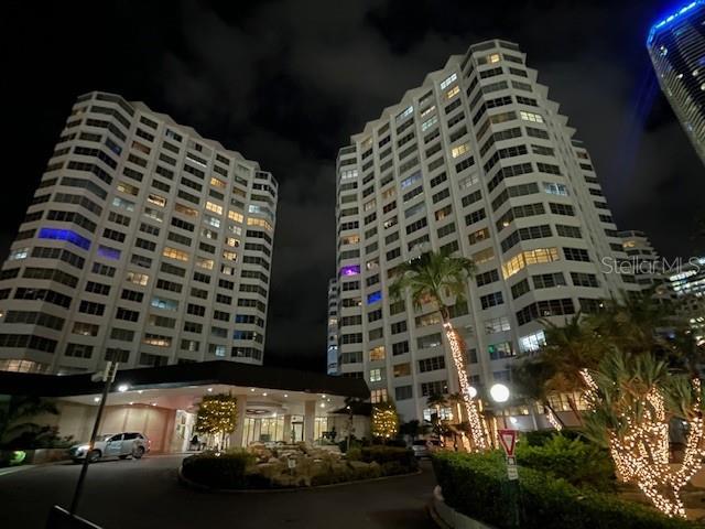 Two tall residential buildings are illuminated at night with a landscaped entrance in the foreground — 999 BRICKELL BAY DRIVE UNIT 1202, MIAMI, FL
