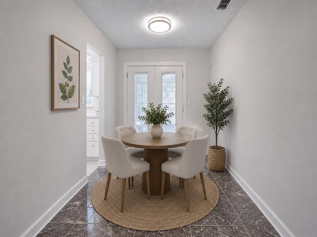 A dining area features a round wooden table, four chairs, and a potted plant — 1245 HONEYTREE LN E LANE E, LAKELAND, FL