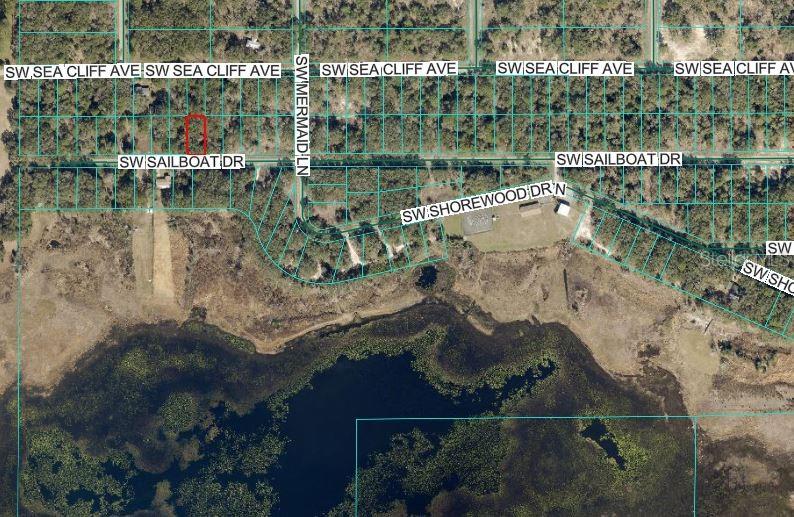 An aerial map shows a rectangular plot of land highlighted in red near a lake — SW SAILBOAT DRIVE, DUNNELLON, FL