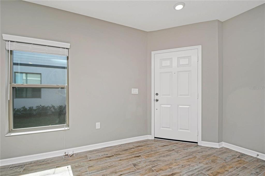 An entryway features light gray walls, wood-look tile flooring, a window, and a white door — 310 CEDAR BARK LANE, SANFORD, FL
