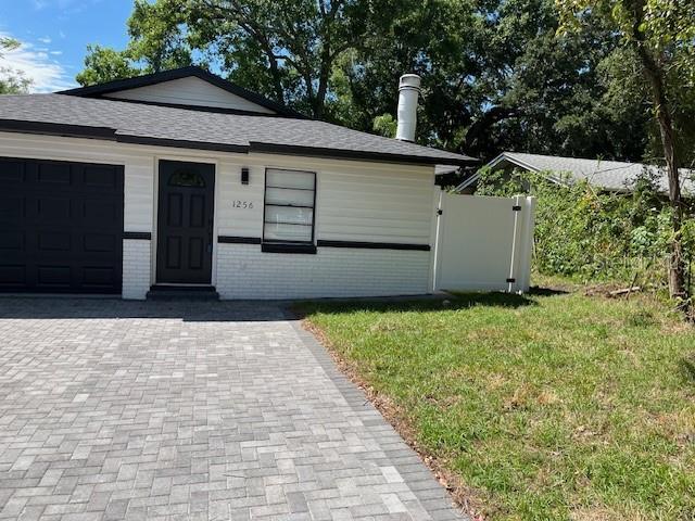 A single-story house with a white brick exterior, dark door, and a paved driveway — 1256 S BUMBY AVENUE, ORLANDO, FL