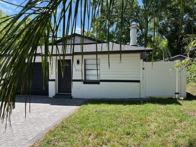 A single-story house with white siding, a brick base, and a paved driveway — 1256 S BUMBY AVENUE, ORLANDO, FL