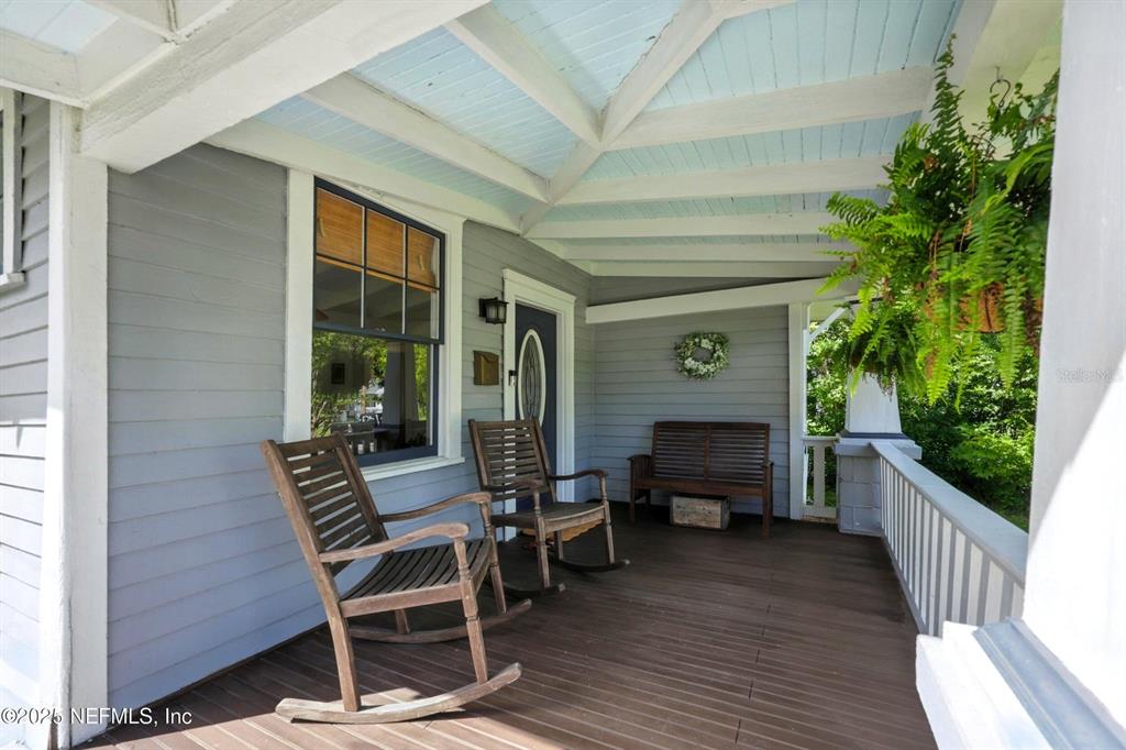 A covered front porch features wooden rocking chairs, a bench, and a hanging fern — 3522 RANDALL STREET, JACKSONVILLE, FL