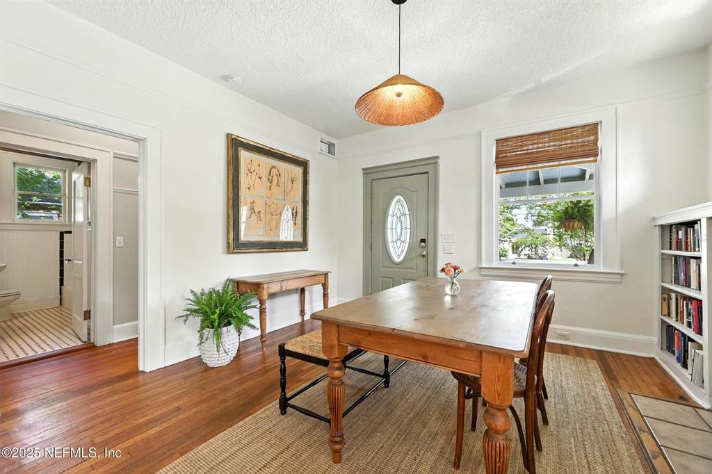 A dining room features hardwood floors, a wooden table, a pendant light, and a bookshelf — 3522 RANDALL STREET, JACKSONVILLE, FL