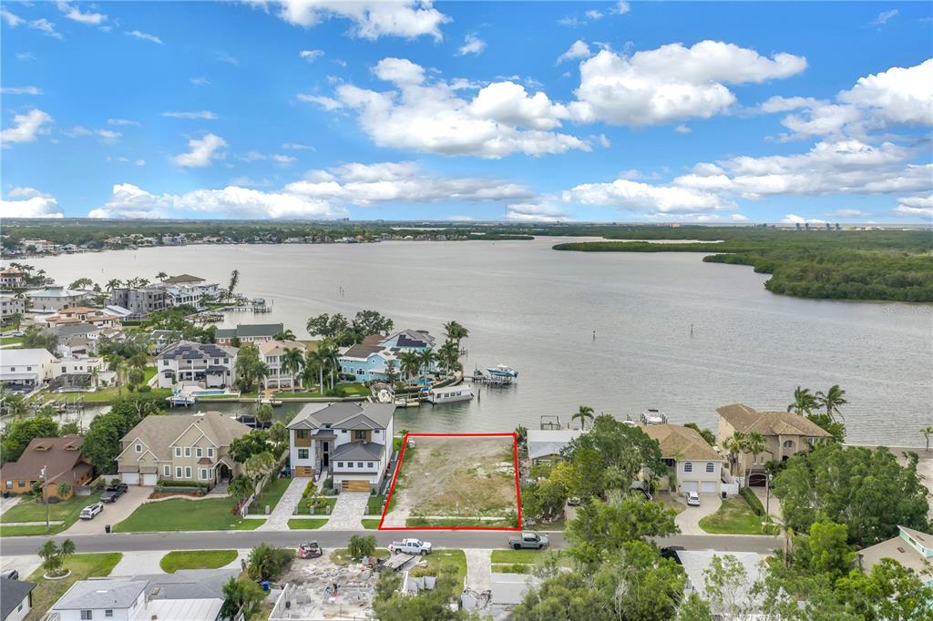 An aerial view shows a vacant waterfront lot outlined in red between two houses — 2129 BAYOU GRANDE BOULEVARD NE, ST PETERSBURG, FL