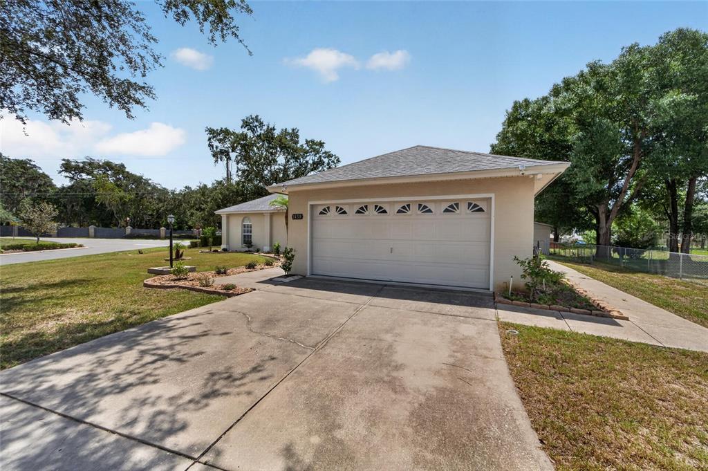 A single-story house with a beige exterior, a two-car garage, and a concrete driveway — 1459 WYNGATE LANE, LAKELAND, FL
