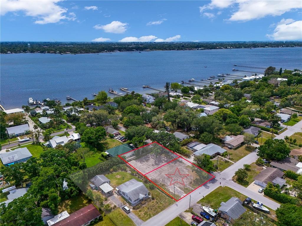 An aerial view shows two adjacent vacant residential lots outlined in red near a waterfront — 1615 5TH STREET W, PALMETTO, FL