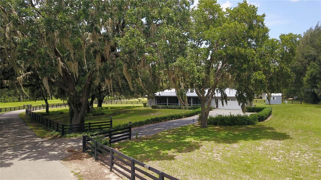 A single-story house with a screened porch and attached garage sits on a grassy lot — 16945 W PHIL C PETERS ROAD, WINTER GARDEN, FL