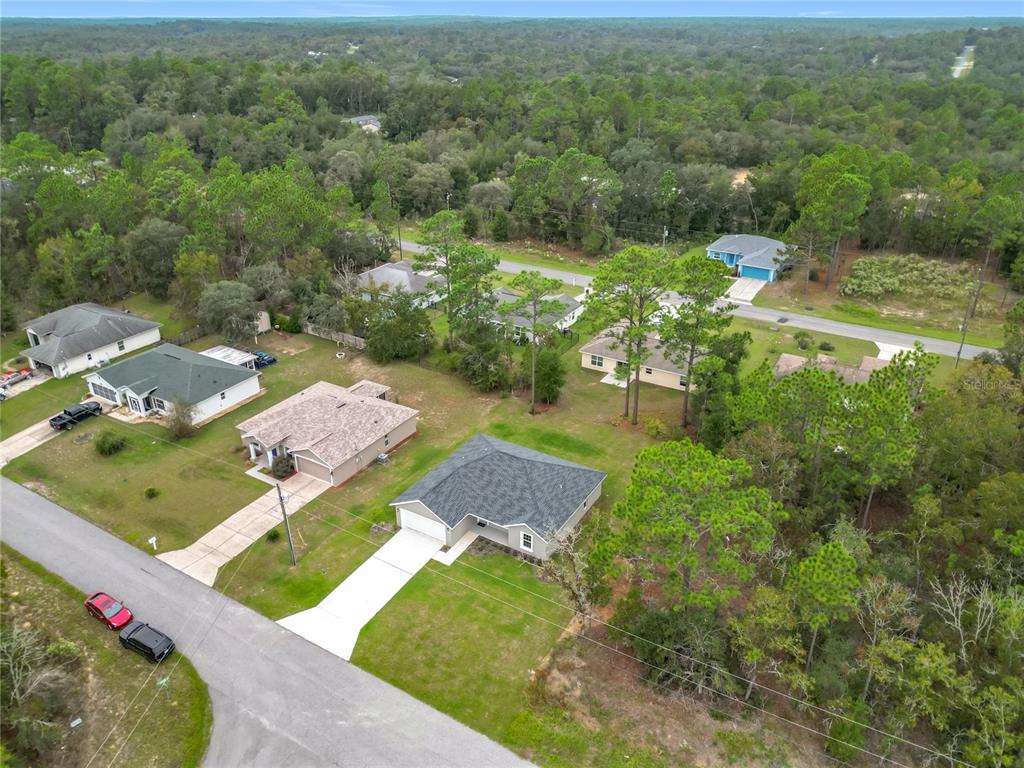 An aerial view shows several single-family homes surrounded by trees and a paved road — 6526 N EARLSHIRE TERRACE, CITRUS SPRINGS, FL