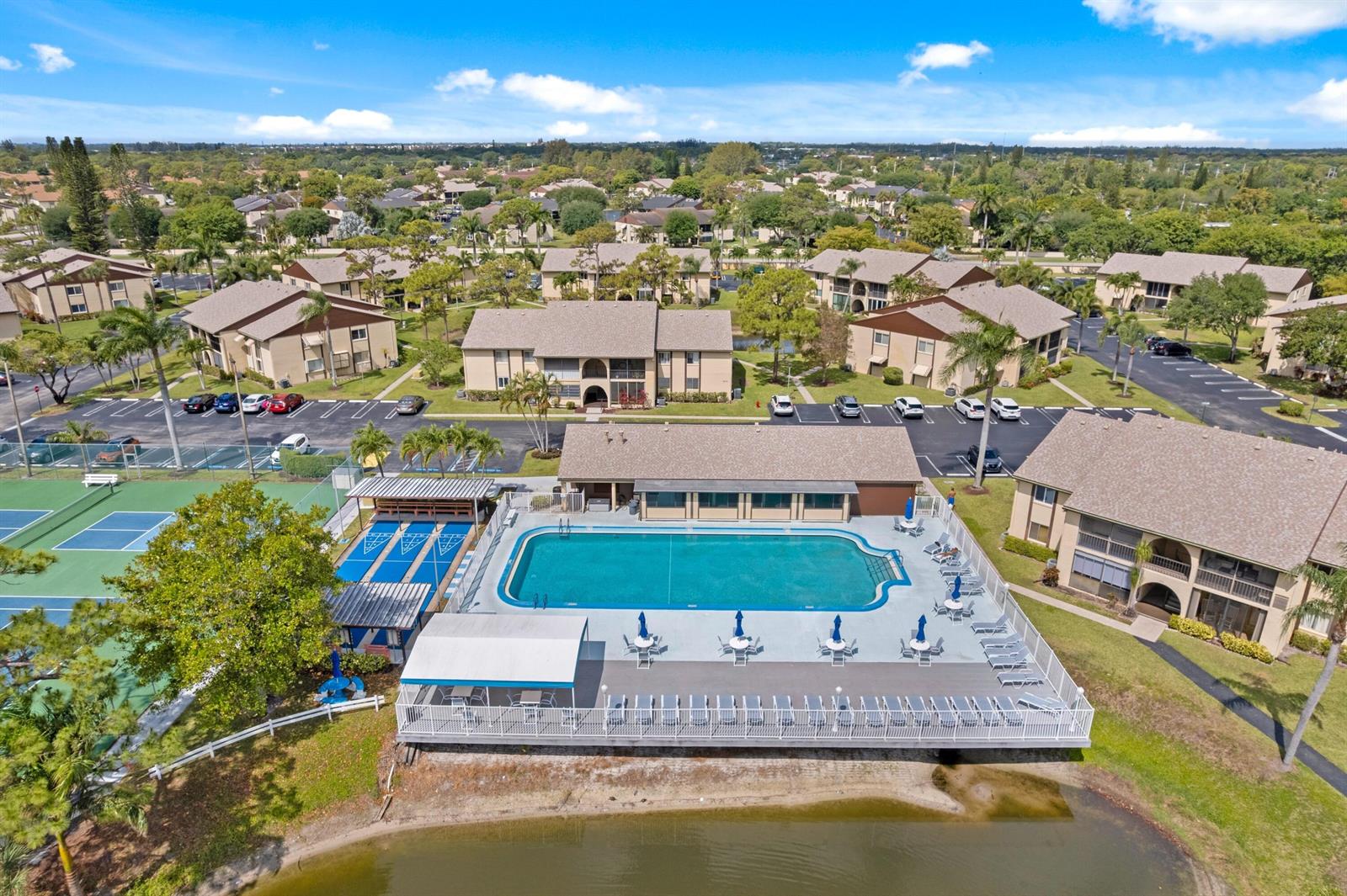 An aerial view shows an apartment complex with a swimming pool, tennis courts, and parking — 339 Pine Ridge Circle # 1, FL 33463, FL