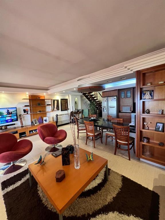 A living room features red swivel chairs, a wooden coffee table, and a dining area — urb. Isla Marina AVENIDA LA COSTA (ANZOÁTEGUI, VENEZUELA) UNIT 10, LECHERIA, OC