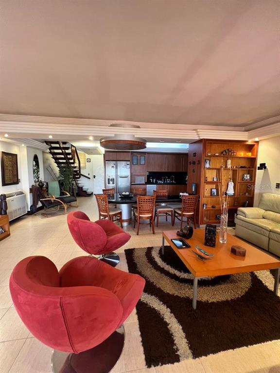 A living and dining area features red swivel chairs, a wooden table, and a staircase — urb. Isla Marina AVENIDA LA COSTA (ANZOÁTEGUI, VENEZUELA) UNIT 10, LECHERIA, OC