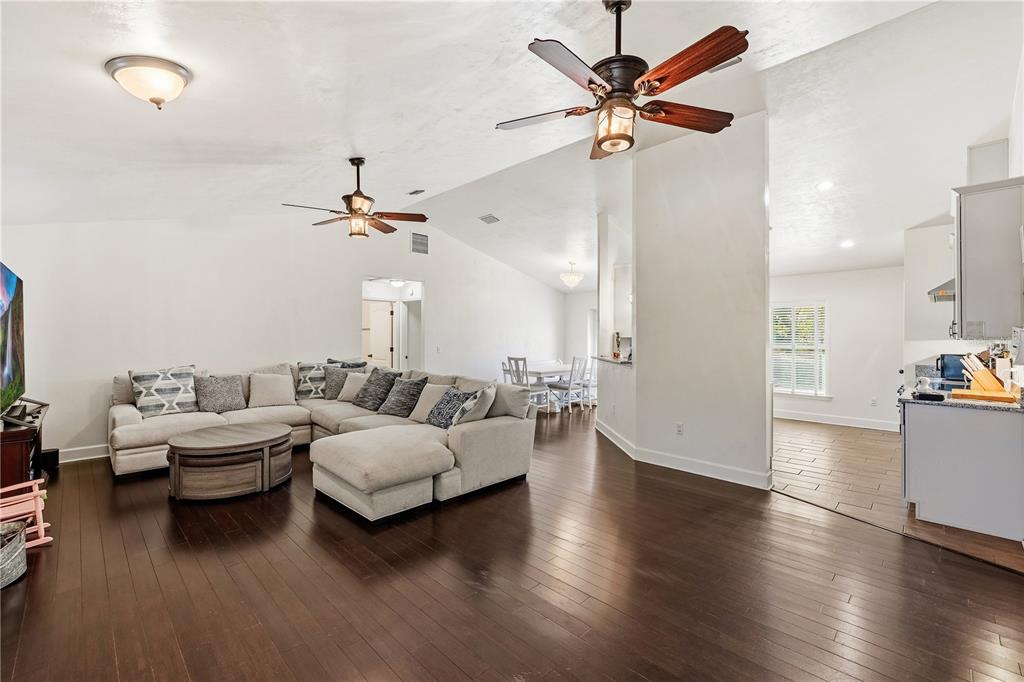 A living room with dark hardwood floors, a sectional sofa, and two ceiling fans — 3353 NE 71ST AVENUE, HIGH SPRINGS, FL