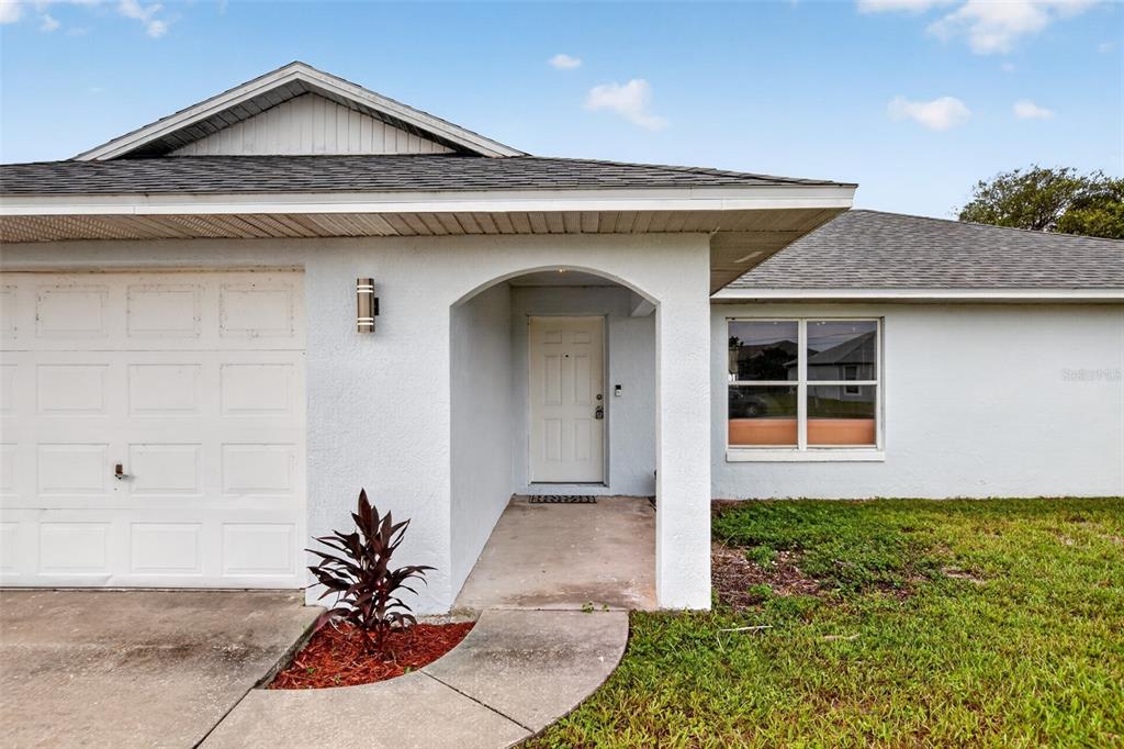 A single-story house exterior features a white garage, a covered entryway, and a front window — 2941 BEDFORD STREET, DELTONA, FL