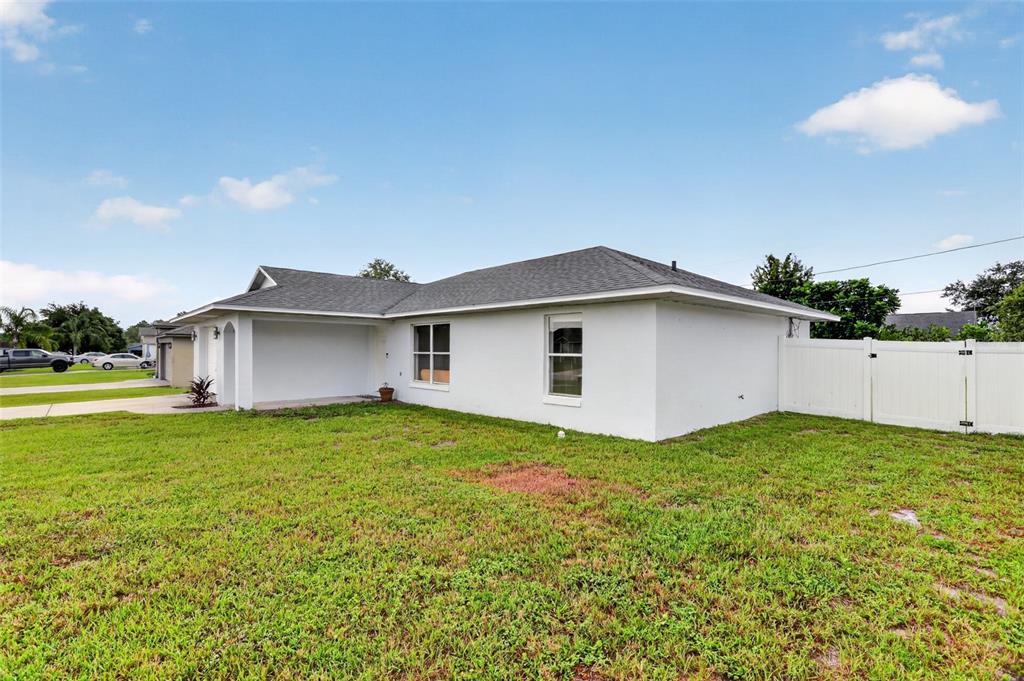 A white, single-story house with a gray shingled roof and a white vinyl privacy fence — 2941 BEDFORD STREET, DELTONA, FL